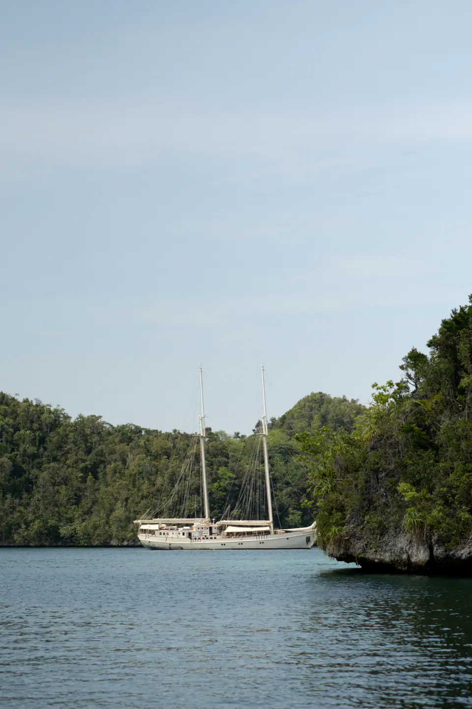 Mutiara Laut anchored near limestone islands in a secluded tropical lagoon.