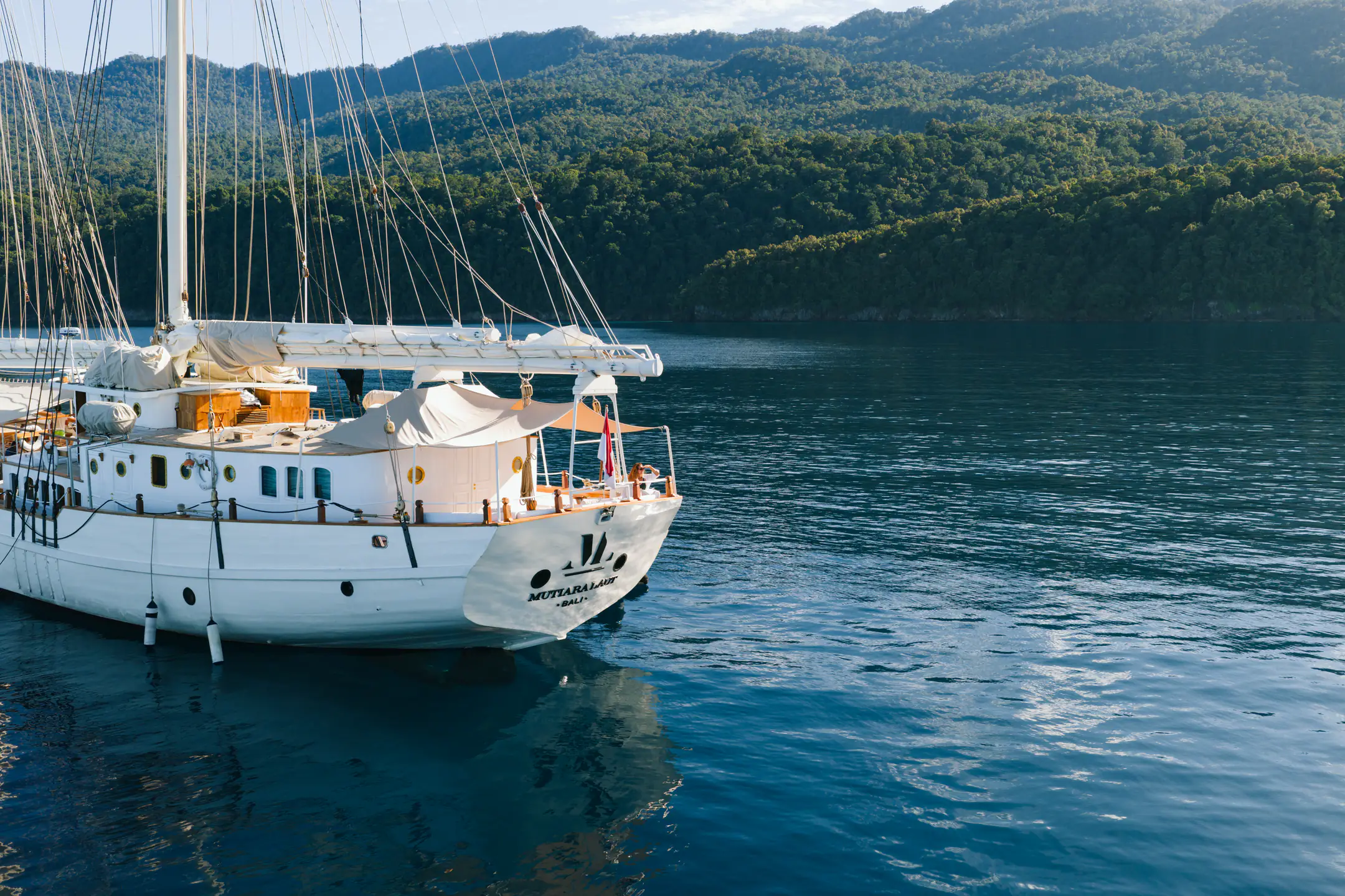 Mutiara Laut anchored in a peaceful bay surrounded by tropical islands.