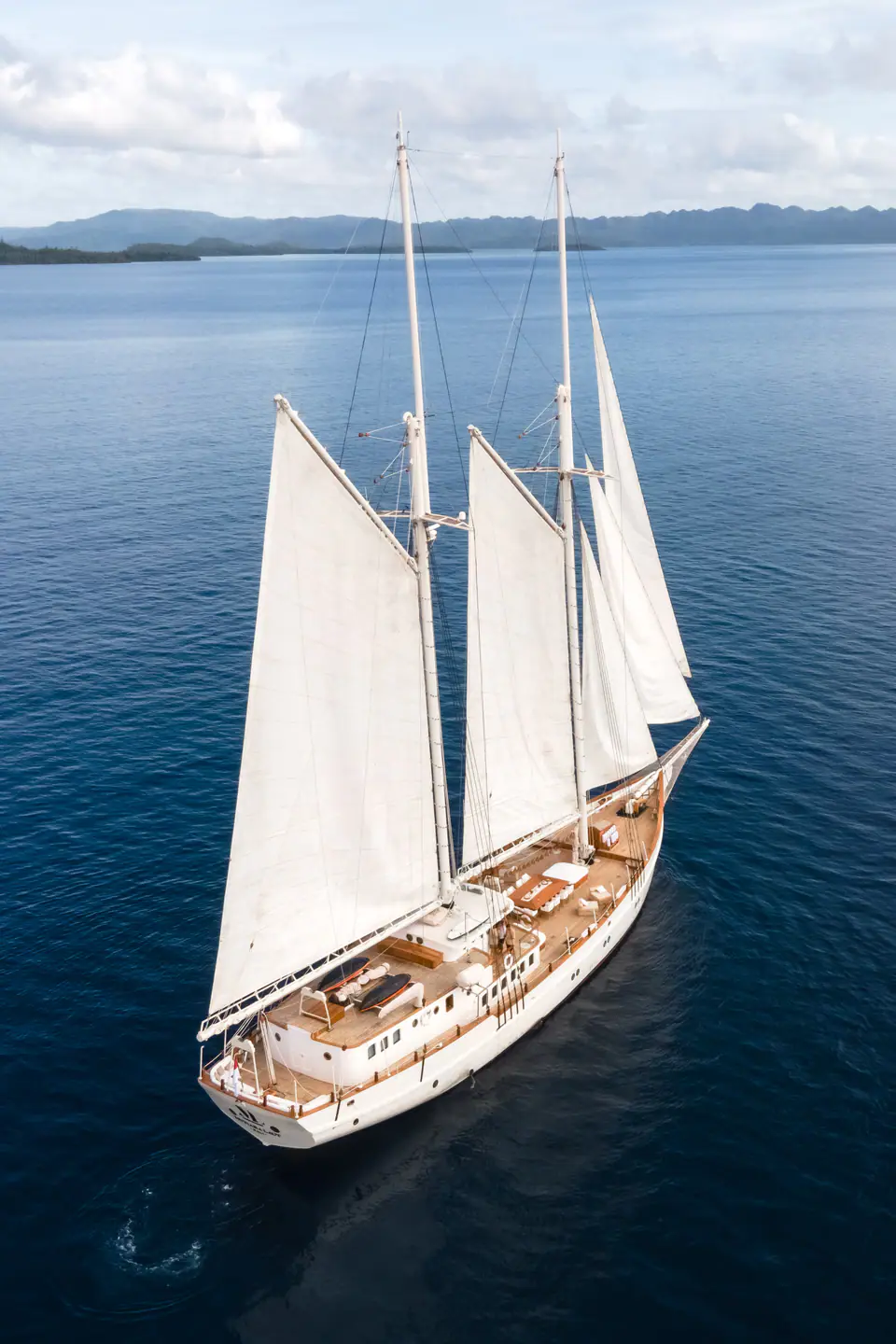 Mutiara Laut Schooner yacht sailing across calm Indonesian waters.