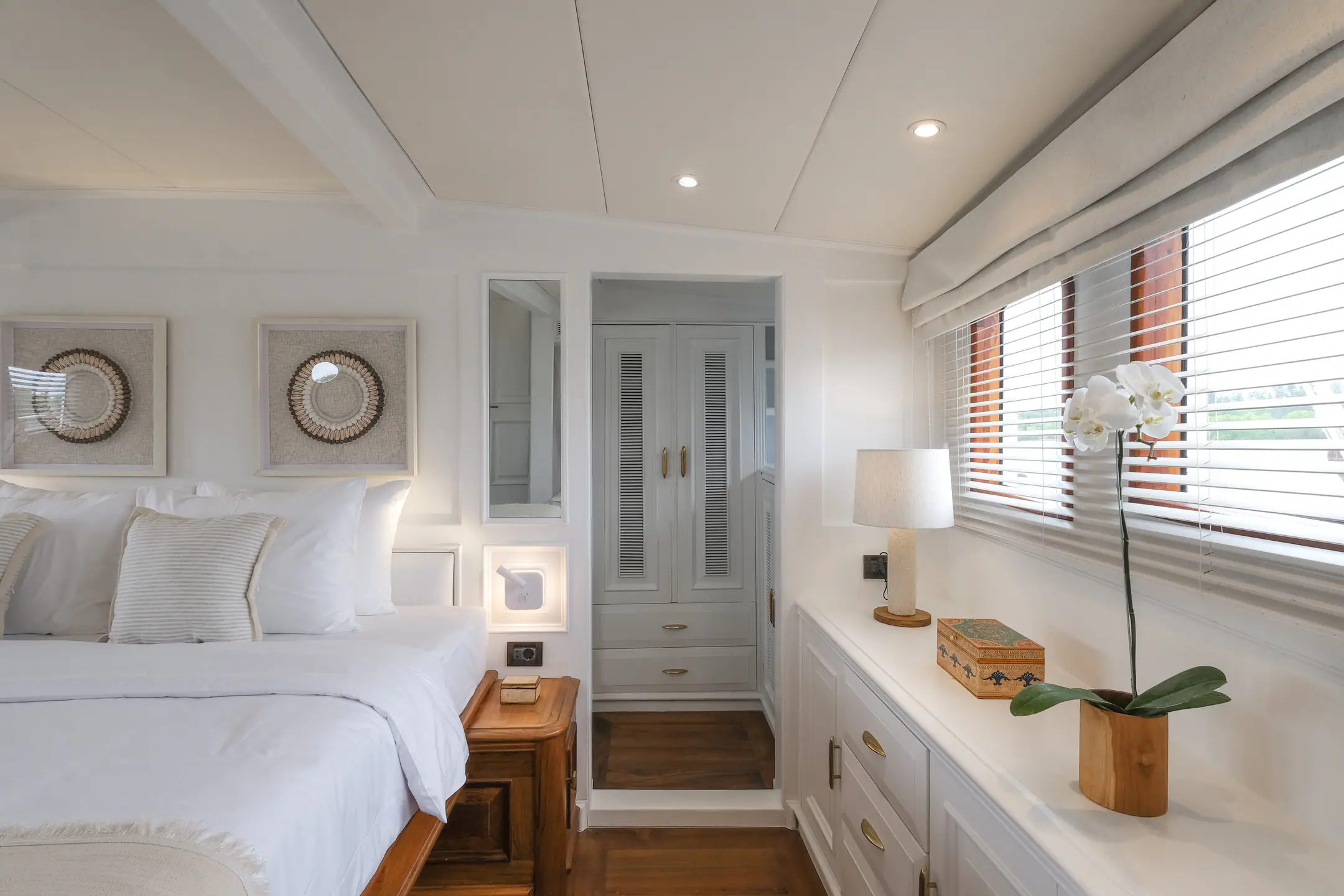 Mutiara Laut guest cabin with bed, desk area and large windows overlooking the sea.