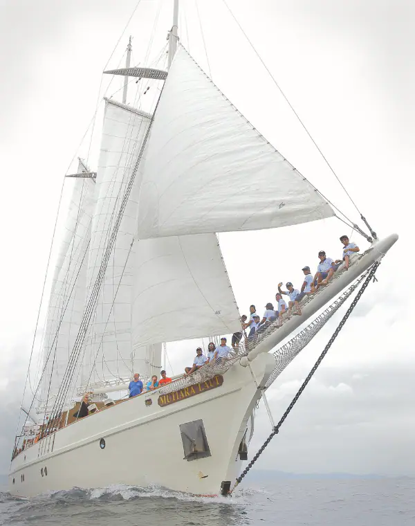 Mutiara Laut seen from the front with the crew sitting on the bow.